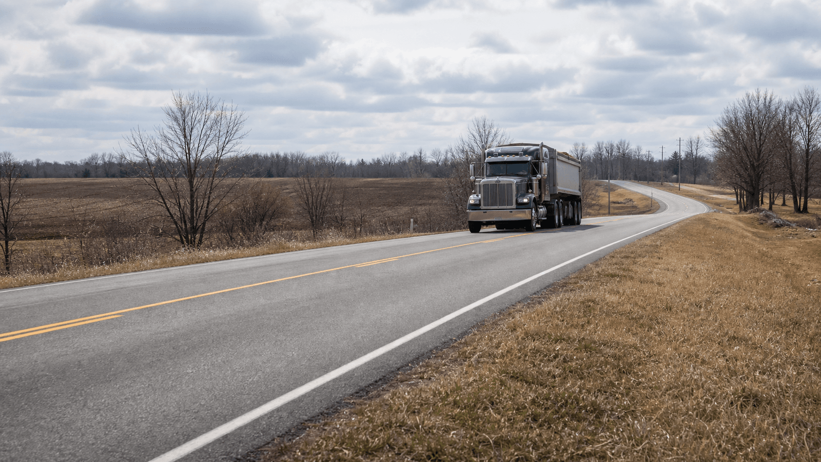 Photorealistic editorial image of a heavy truck on a rural Ontario road in spring.